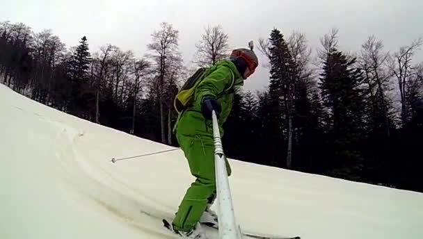 Skier going downhill  with camera on his helmet and in hand — Stock Video