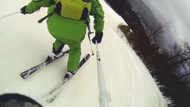 Skier going downhill  with camera on his helmet and in hand — Stock Video