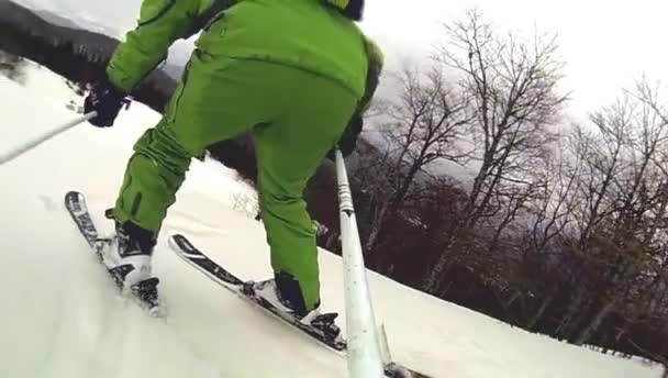 Skier going downhill  with camera on his helmet and in hand — Stock Video