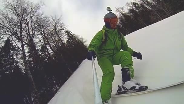 Skier going downhill  with camera on his helmet and in hand — Stock Video