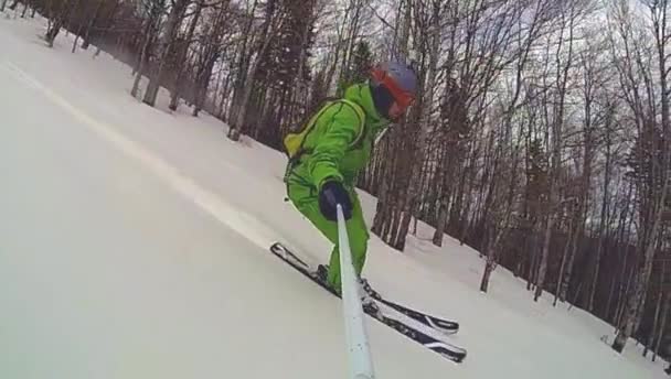 Skieur descendant avec caméra sur son casque et en main — Video