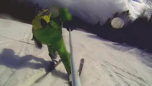 Skier going downhill  with camera on his helmet and in hand — Stock Video