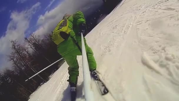 Skier going downhill  with camera on his helmet and in hand — Stock Video