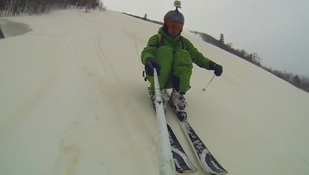 Skier going downhill  with camera on his helmet and in hand — Stock Video