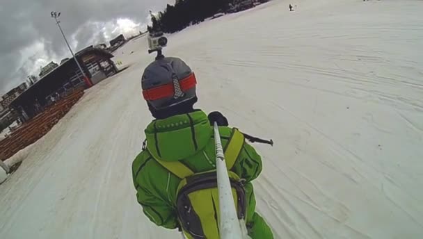 Skier going downhill  with camera on his helmet and in hand — Stock Video