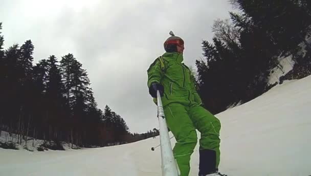 Skier going downhill  with camera on his helmet and in hand — Stock Video