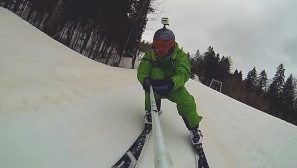 Skier going downhill  with camera on his helmet and in hand — Stock Video