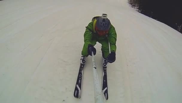 Skier going downhill  with camera on his helmet and in hand — Stock Video