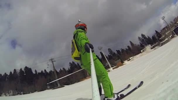 Skier going downhill  with camera on his helmet and in hand — Stock Video