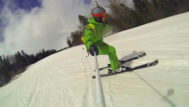 Skier going downhill  with camera on his helmet and in hand — Stock Video