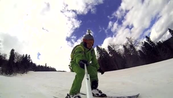 Skier going downhill  with camera on his helmet and in hand — Stock Video