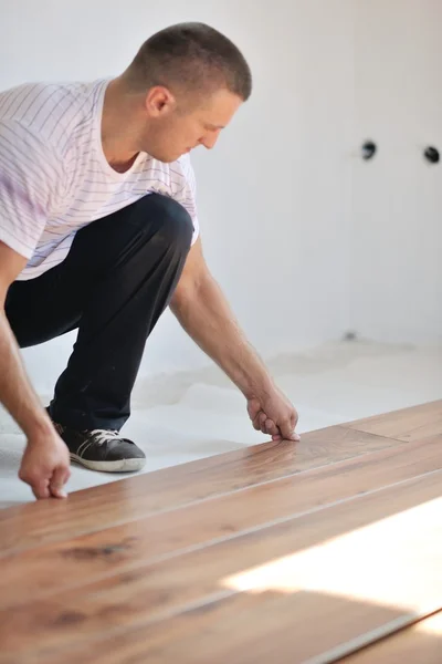 Homme installant plancher stratifié — Photo