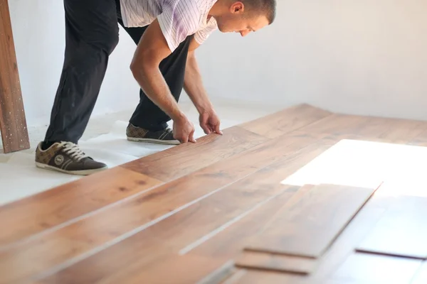 Homme installant plancher stratifié — Photo