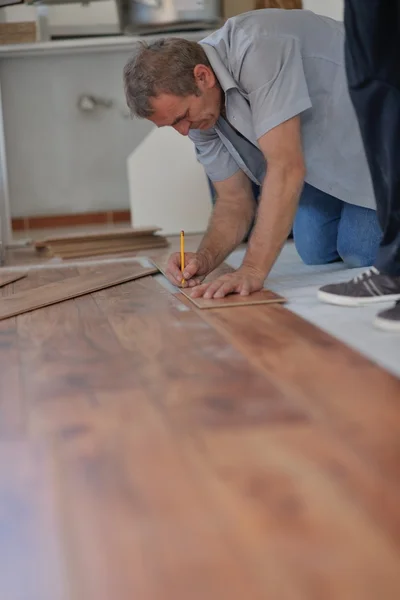 Muž instalující laminátové podlahy — Stock fotografie