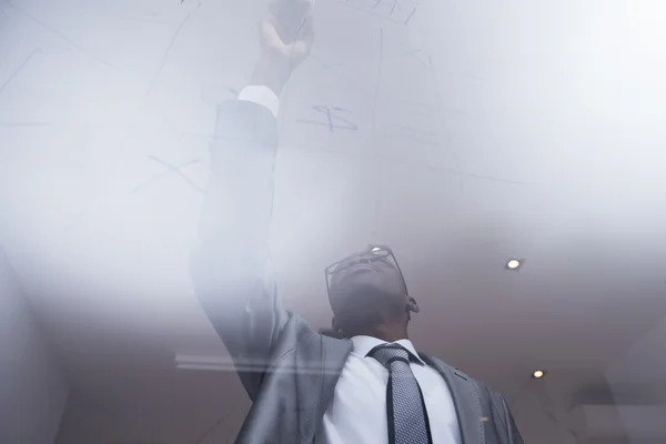 Hombre de negocios dibujando en un tablero — Foto de Stock