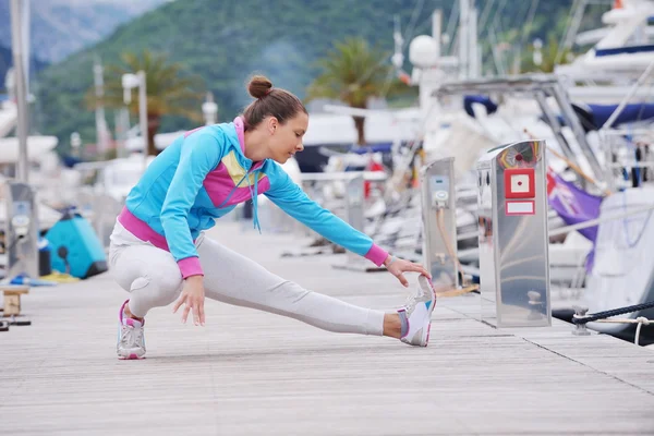 Woman stretching in marina — Stock Photo, Image