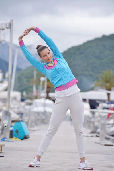 Woman stretching in marina — Stock Photo, Image