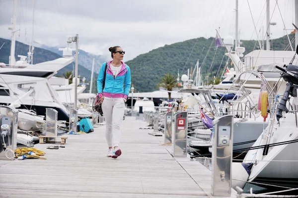 Giovane donna a piedi in marina — Foto Stock