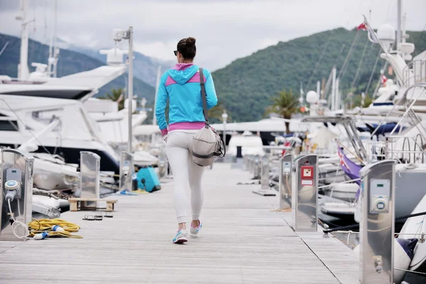 Young woman walking in marina — Stock Photo, Image