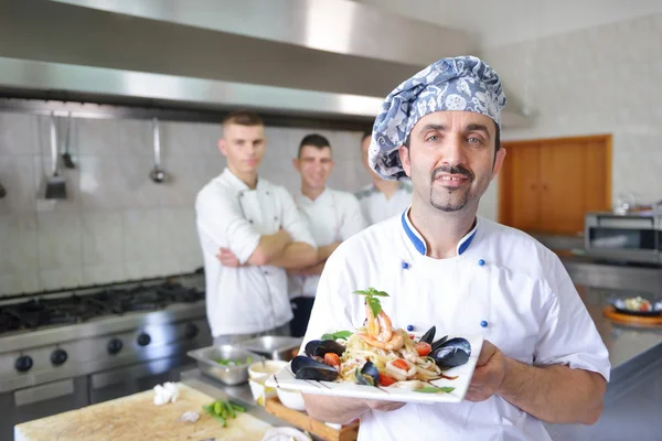 Grupo de guapos chefs vestidos de uniforme blanco —  Fotos de Stock