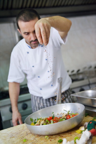 Chef making salad in modern kitchen