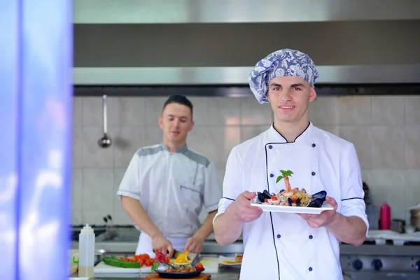 Chef dekoriert Nudelsalat mit Meeresfrüchten — Stockfoto