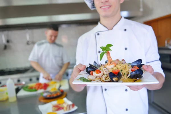 Šéfkuchař zdobení Těstovinový salát z mořských plodů — Stock fotografie