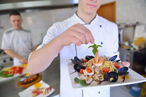Chef dekoriert Nudelsalat mit Meeresfrüchten — Stockfoto