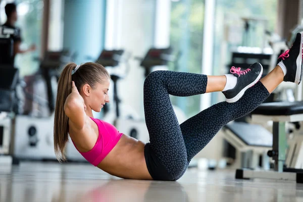 Kvinnan sträcker sig och värmer upp på ett gym — Stockfoto