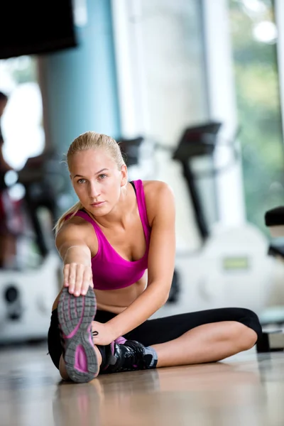 Kvinnan sträcker sig och värmer upp på ett gym — Stockfoto