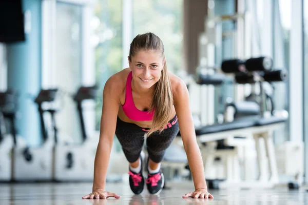 Mujer calentando y haciendo algunos flexiones —  Fotos de Stock