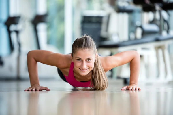 Mujer calentando y haciendo algunos flexiones —  Fotos de Stock