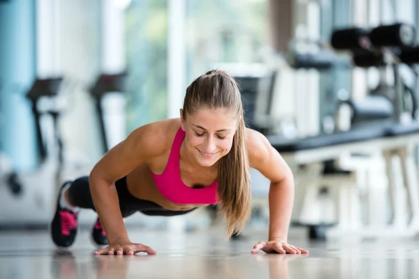 Mujer calentando y haciendo algunos flexiones — Foto de Stock