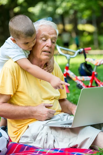 Grandfather and child using laptop computer — Stock Photo, Image