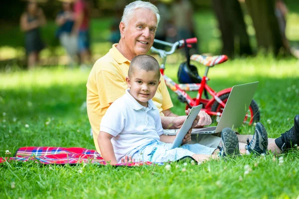 Grandfather and child using laptop and tablet computer — Stock Photo, Image