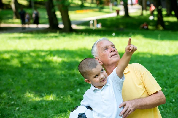 Grand-père et enfant s'amusent dans le parc — Photo