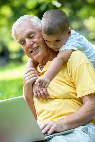 Grandfather and child using laptop computer — Stock Photo, Image