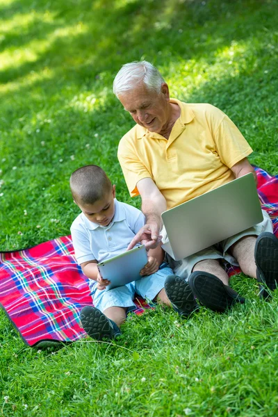 Grandfather and child using laptop and tablet computer — Stock Photo, Image