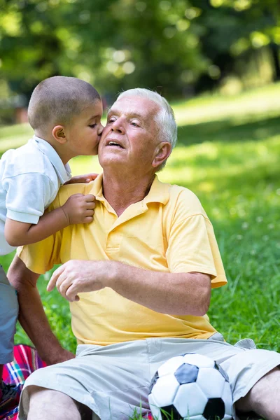 Isoisä ja lapsi pitää hauskaa puistossa — kuvapankkivalokuva