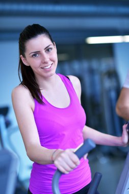 Spor salonunda koşu bandında egzersiz yapan kadın.