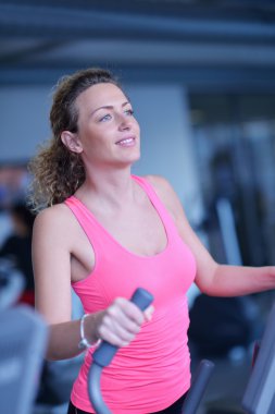 Spor salonunda koşu bandında egzersiz yapan kadın.