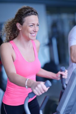 Spor salonunda koşu bandında egzersiz yapan kadın.