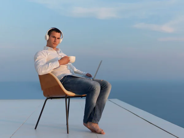 Расслабленный молодой человек на домашнем балконе — стоковое фото