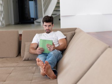 Evde tablet bilgisayar kullanan adam