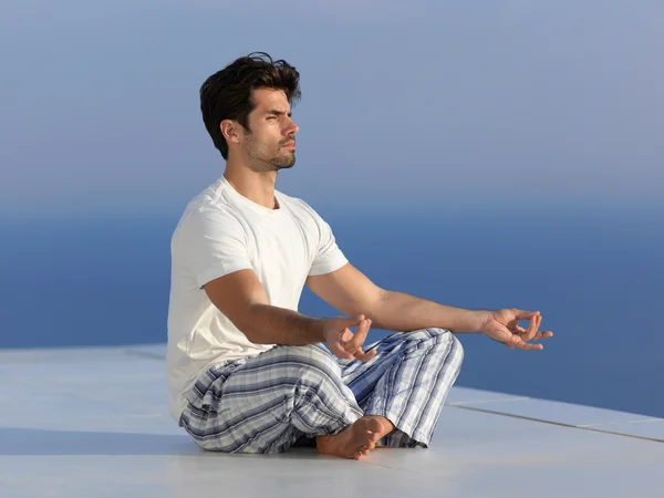 Jeune homme pratiquant le yoga — Photo