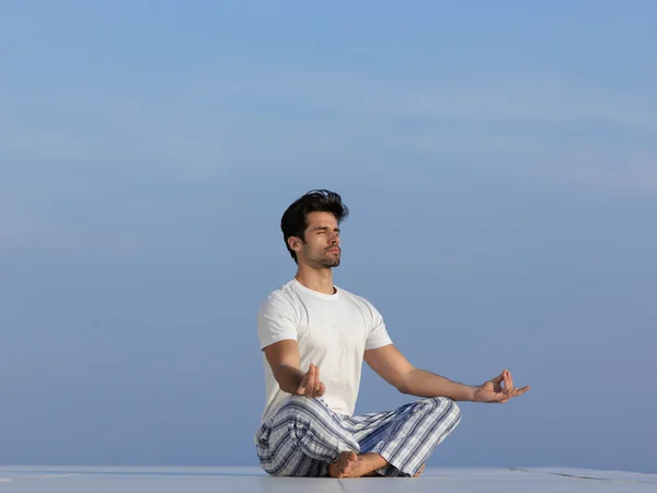 Junger Mann praktiziert Yoga — Stockfoto