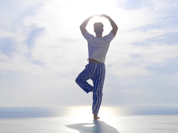 Ung mand praktiserer yoga - Stock-foto