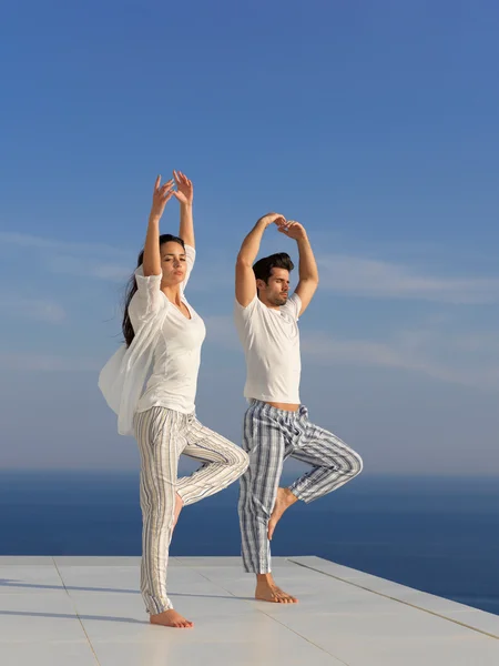 Ungt par, der praktiserer yoga - Stock-foto