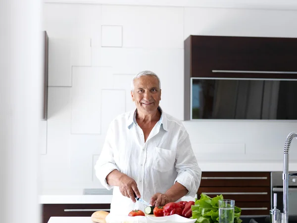 Man cooking at home preparing salad — Stock Photo, Image