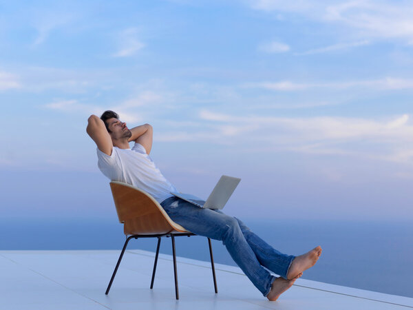 Расслабленный молодой человек на домашнем балконе
